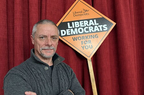 Selected Candidate, Greg Broadhurst standing firmly infront of lib dem poster